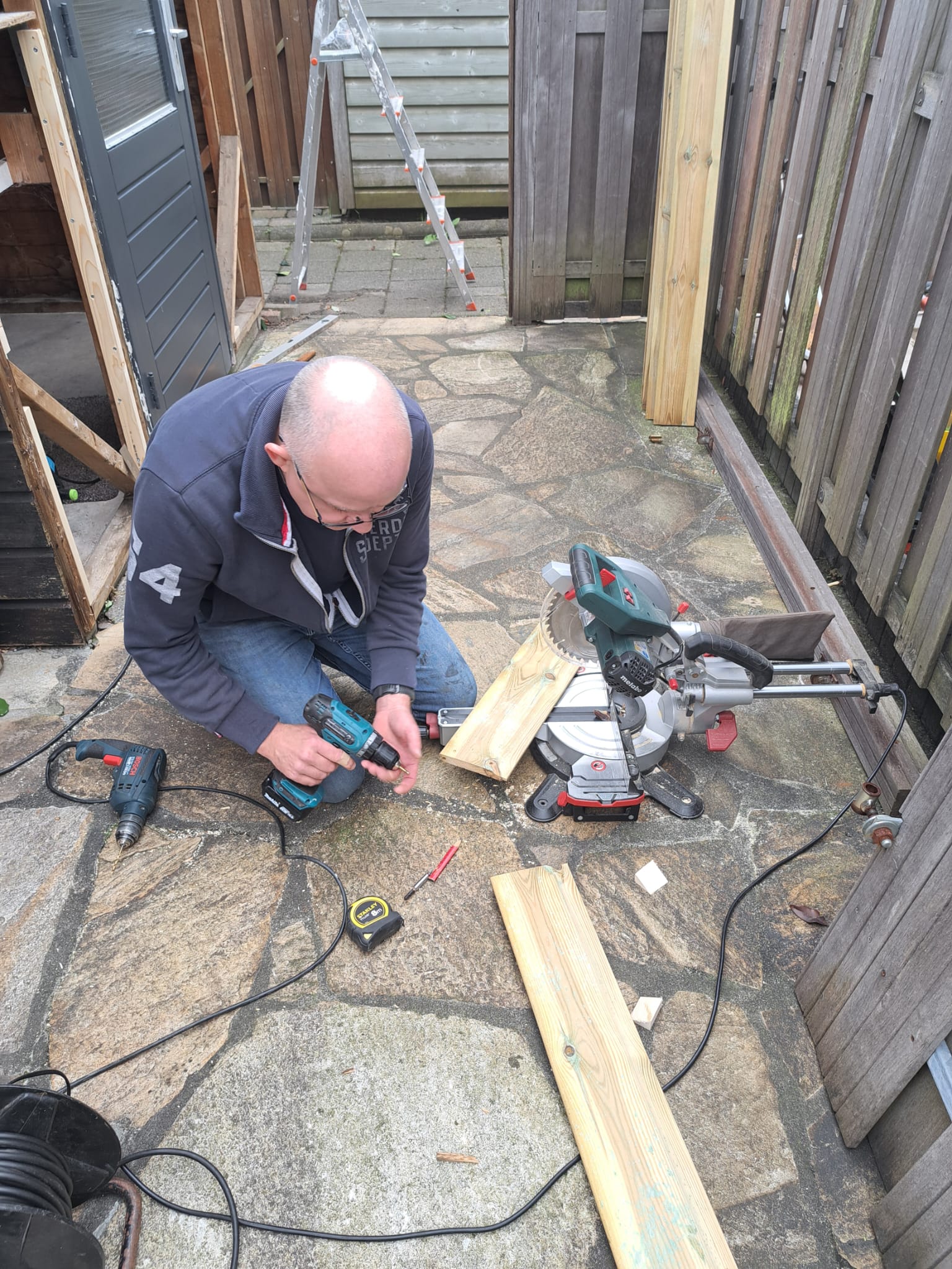 Arnoud Oostveen aan het werk met hout en gereedschap.