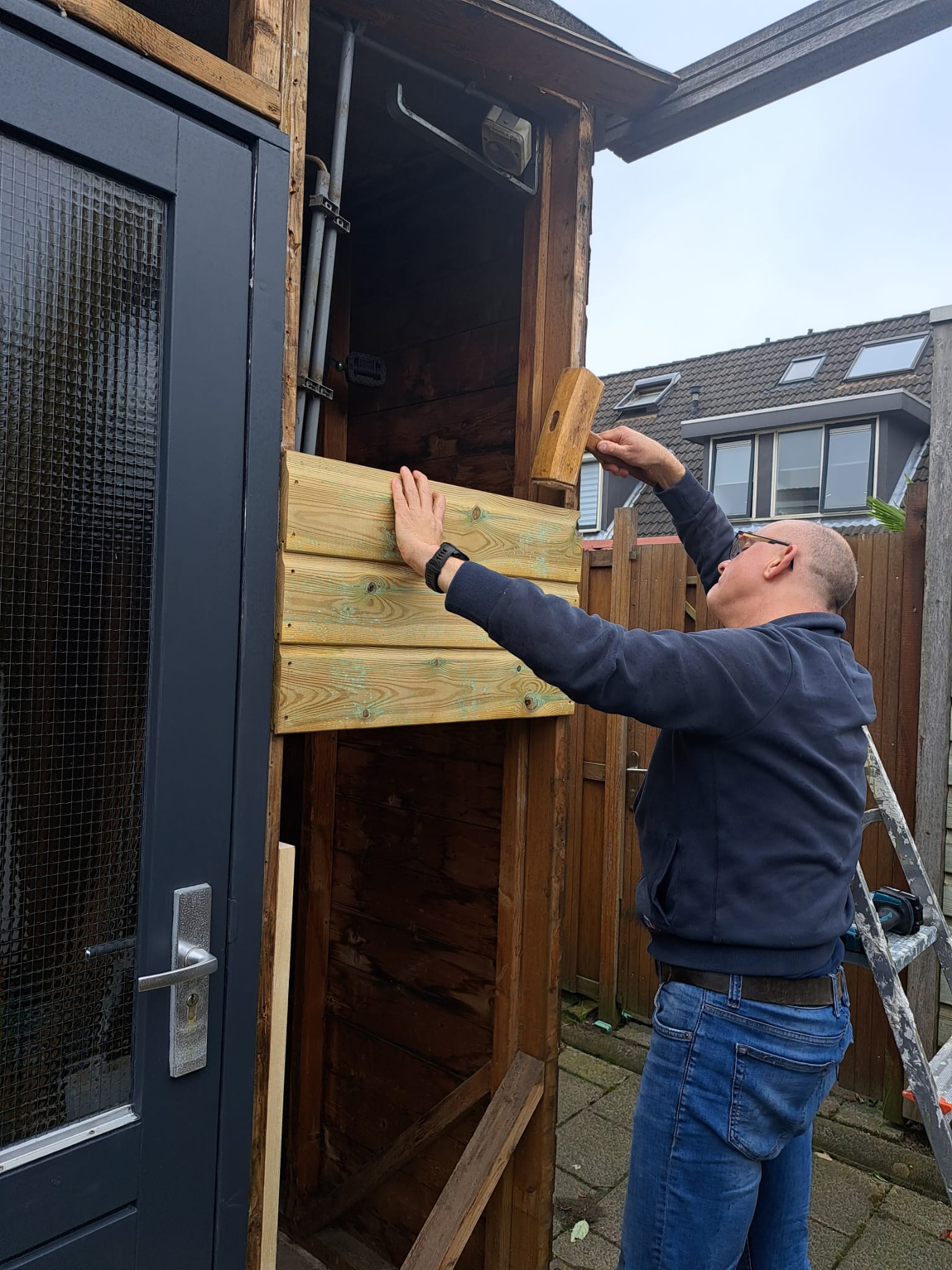 Arnoud Oostveen maakt een houten wand passend bij een kozijn.