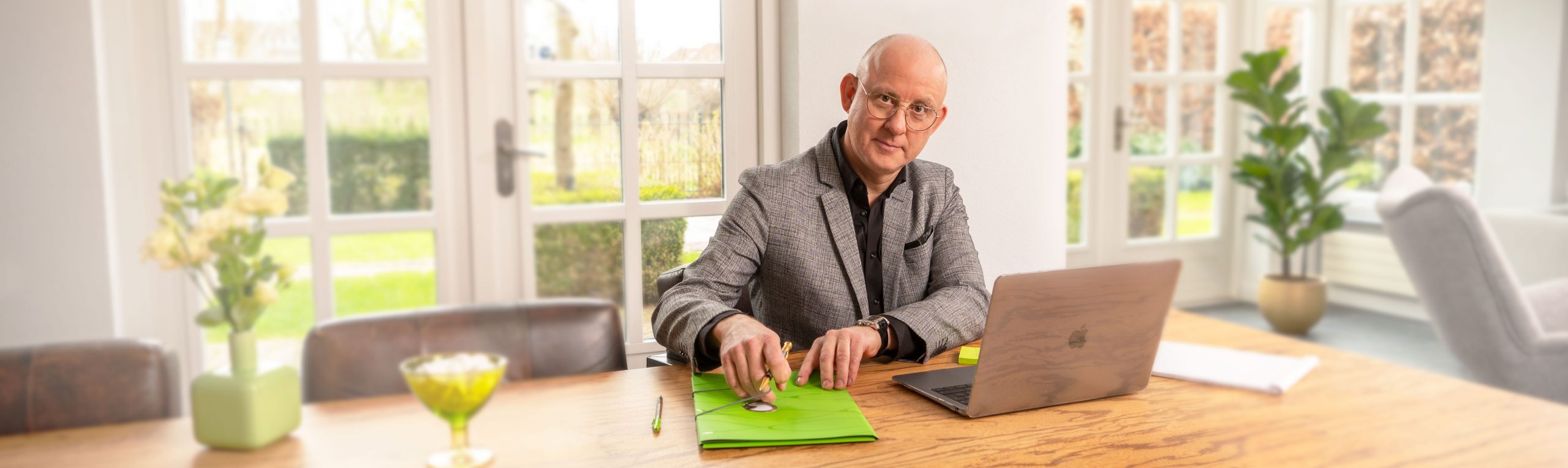 Arnoud Oostveen als adviseur, zittend aan tafel met een laptop.